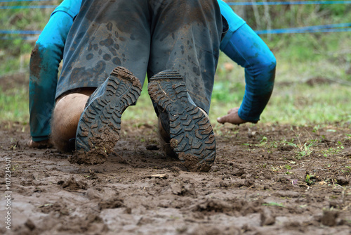 Mud race runners,crawling under a barbed wire