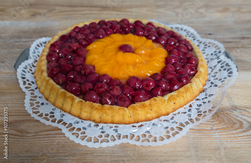 Obstboden mit Kirschen und Mandarinen auf rustikalem Holz photo