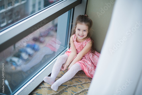 Little girl sitting on the floor and smiling, cute, mischief, childhood