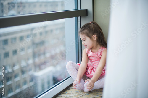 Little girl sitting on the floor and smiling, cute, mischief, childhood