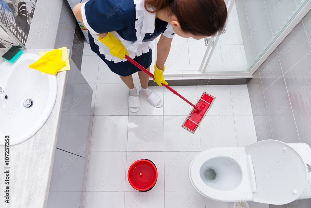 Housekeeper or maid mopping the floor