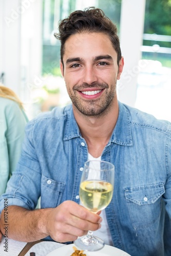 Portrait of happy man holding white wine glass