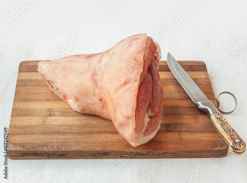 Photo Pork shank raw on a cutting board