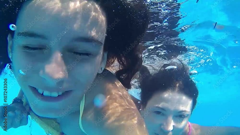 Mother and daughter smiling under water