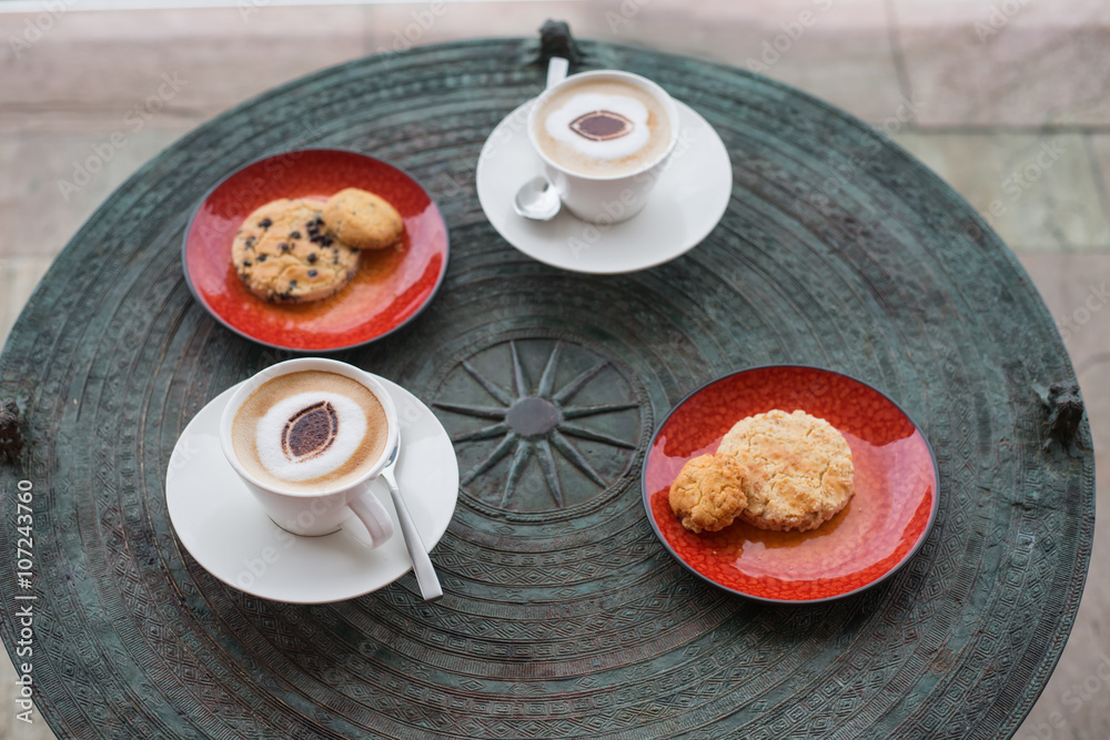 Cappuccino in white circles with cookies, anasa on a table