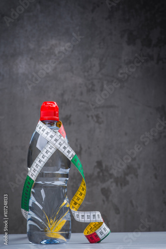 Bottle of fresh still water with measuring tape