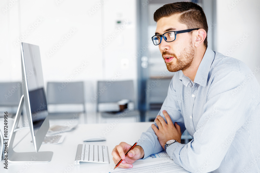 Fototapeta premium Male office worker sitting at desk