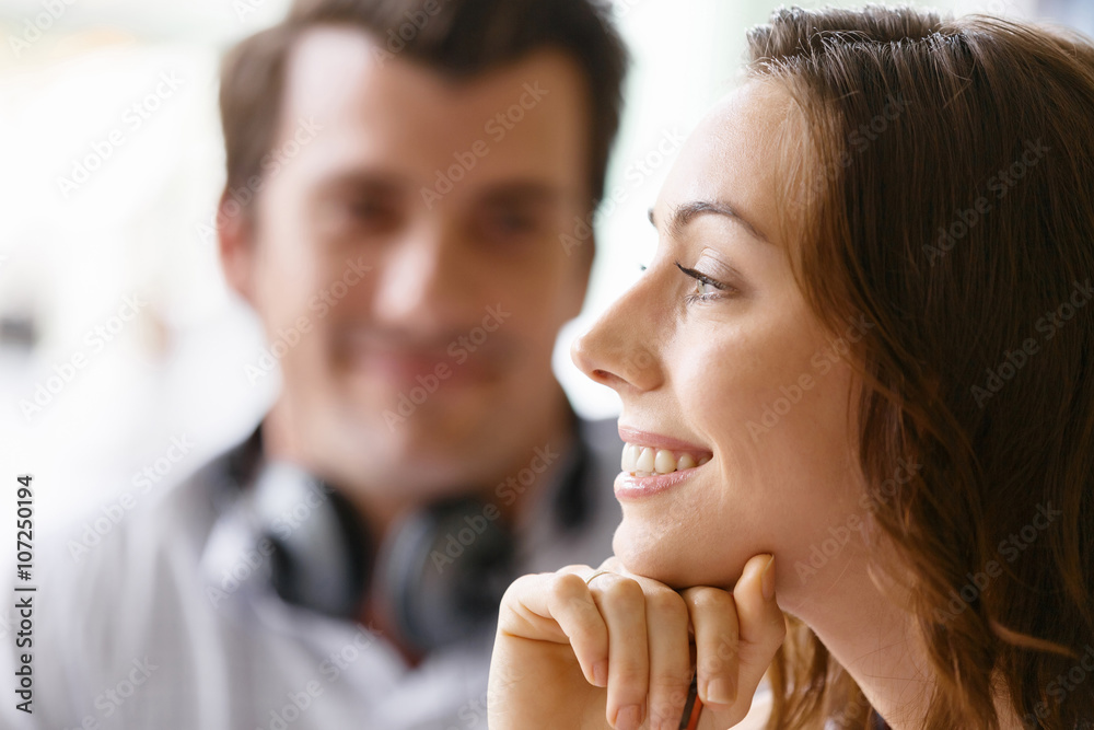 Young pretty woman smiling with man on background Young pretty woman smiling with man on background