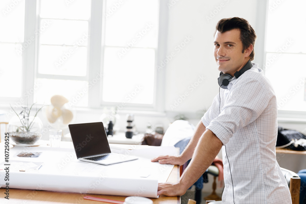 Young man standing in creative office