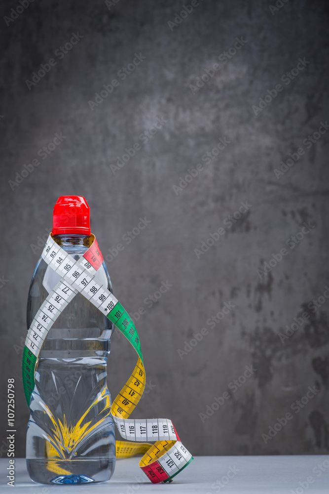 Bottle of fresh still water with measuring tape