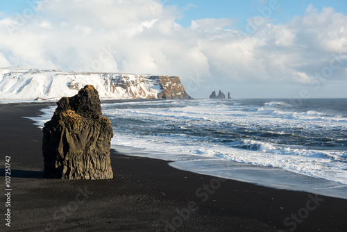 Winter landscape with Reynisdrangar stacks, mountain, black sand beach and ocean waves, Iceland