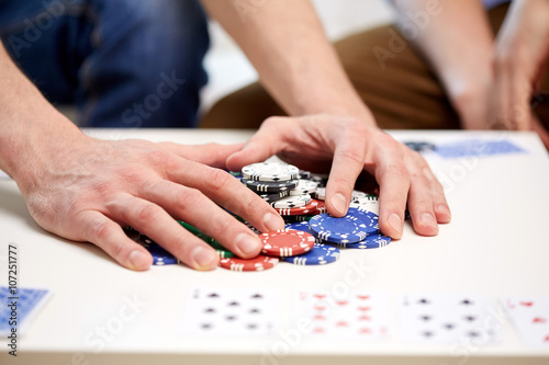 hands with casino chips making bet or taking win