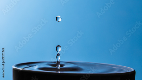 Gocce d'acqua in tazza su sfondo azzurro