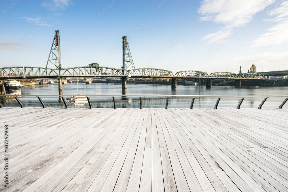 empty wood floor with steel bridge over sea in portland