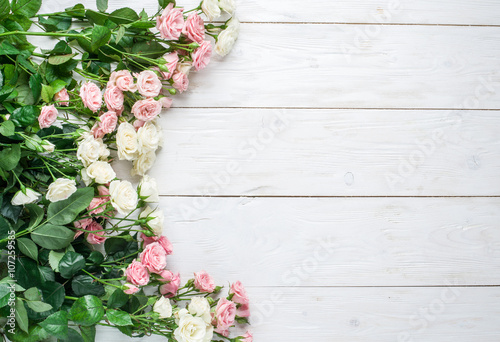 Delicate fresh roses on the white wooden background.