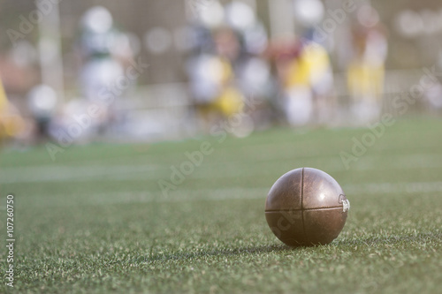 American football ball and players in the background 