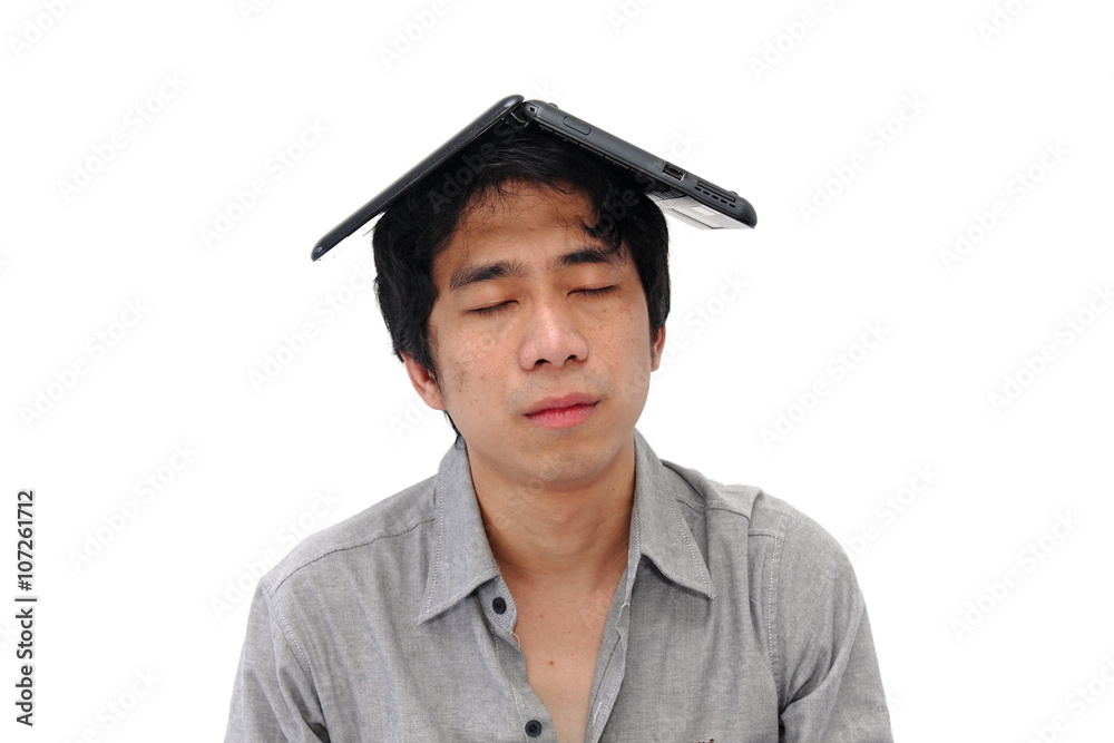 Asian businessman meditating with laptop on head Asian businessman meditating with laptop on head