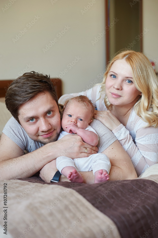mom and dad playing with his baby son on the bed. Happy family concept mom and dad playing with his baby son on the bed. Happy family concept