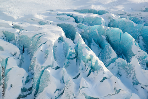 Details of the glacier Svinafellsjokull at winter, blue vivid textured ice covered by snow, Iceland