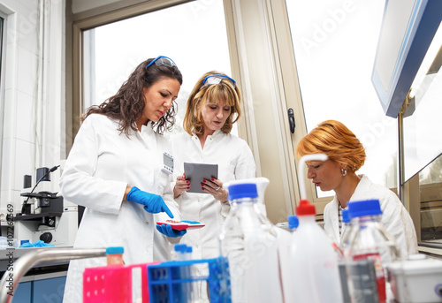 Photo of three real female scientists researching in laboratory.