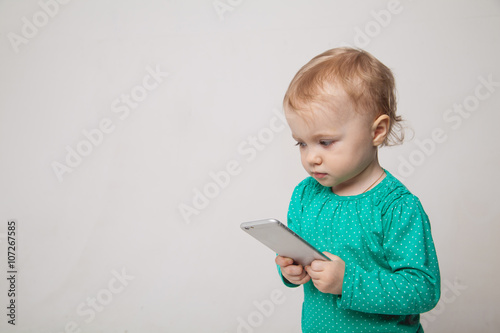Smiling little cute girl  mobile smartphone. Isolated on white background.