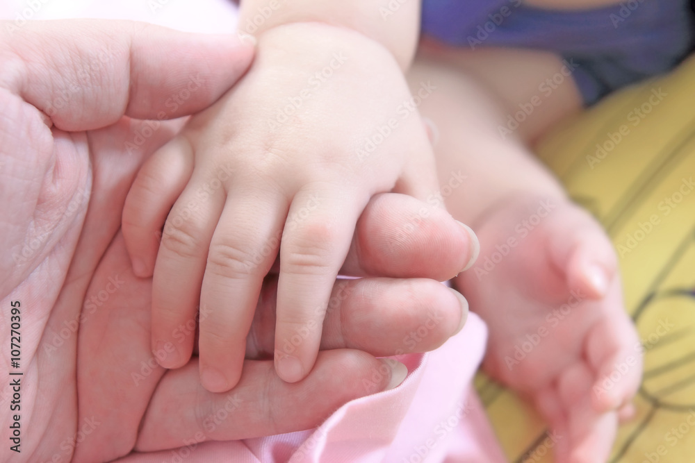 Baby hand in mother's hand, soft focus Baby hand in mother's hand, soft focus