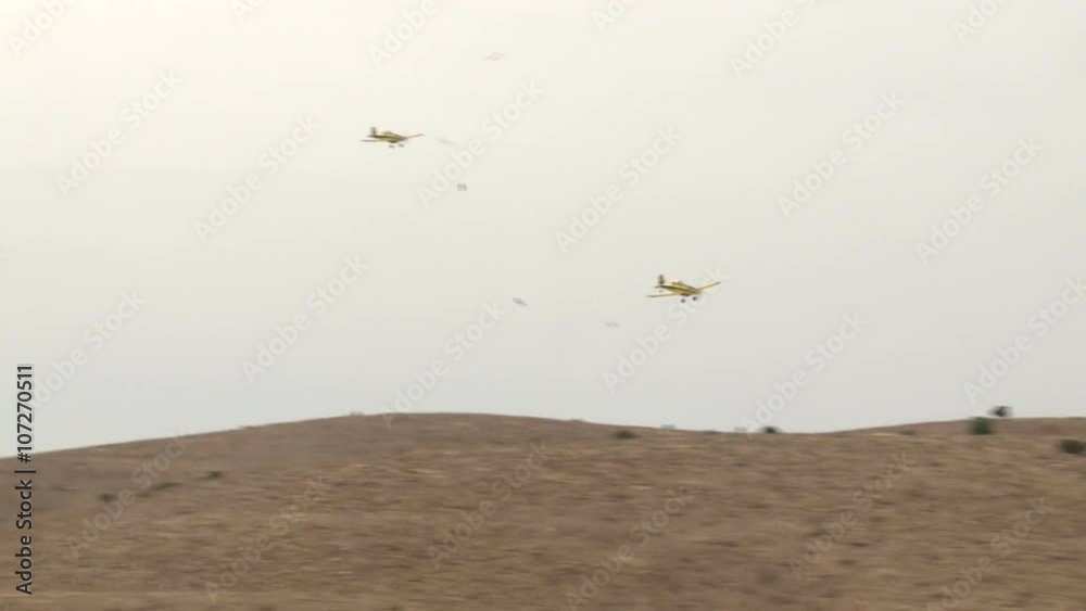 2 Yellow with black stripe fire fighters, crop dusters , agricultural aircraft flies low over a field, mountain with fire and stew splashing, sprays chemicals, water . with sound 2 Yellow with black stripe fire fighters, crop dusters , agricultural aircraft flies low over a field, mountain with fire and stew splashing, sprays chemicals, water . with sound