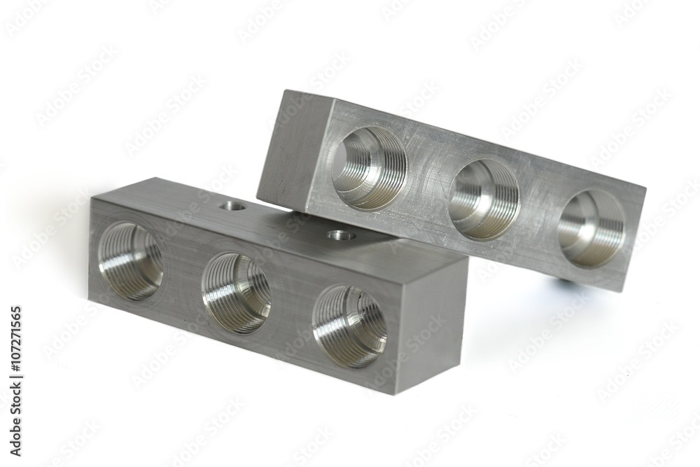 Metal manifold produced by cnc lathe on white background.