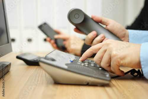 business team is using mobile phone and telephone to contact par