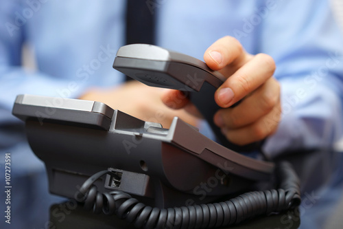 businessman is picking up telephone handset  customer service