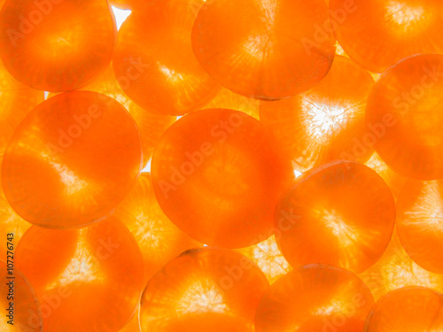 background of back lit ripe carrot slices arranged