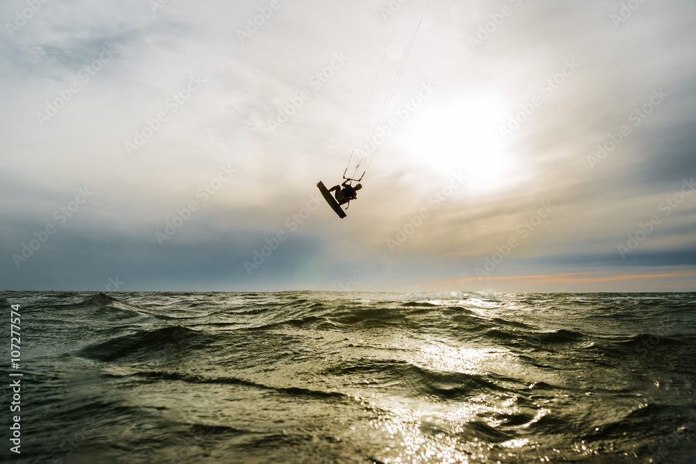 Surfer jumping at the sunset