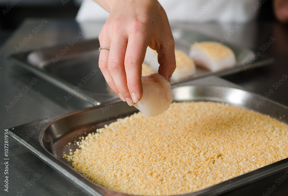 Fresh fish fillet cube being placed into breadcrumbs,before being pan fried. Fresh fish fillet cube being placed into breadcrumbs,before being pan fried.