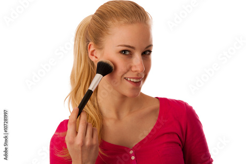 Woman applying pouder with cosmetics brush on cheeck, making mak
