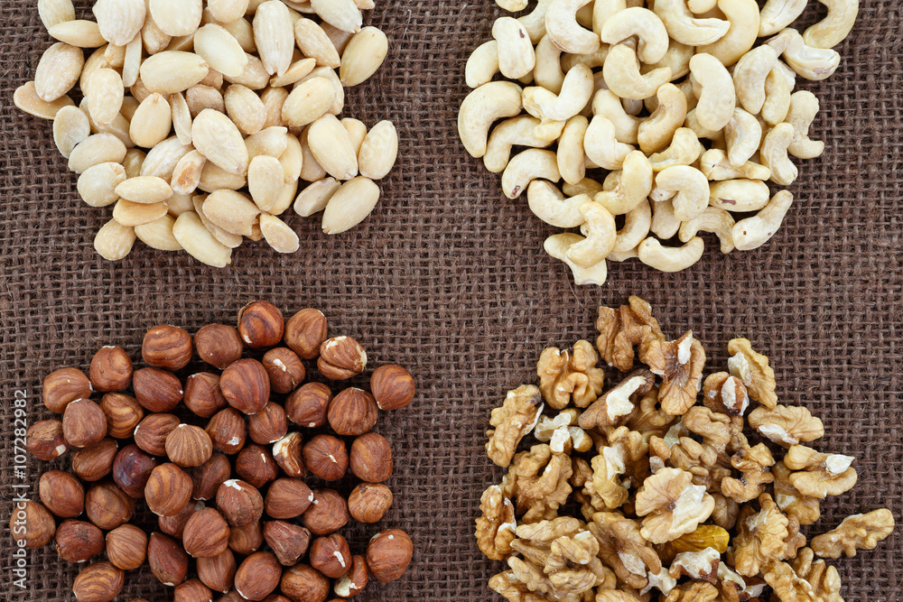 Fototapeta premium Almonds, cashew, walnuts and hazelnuts lying on burlap