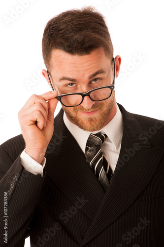 Successful businessman in formal suit looking over glasses isola