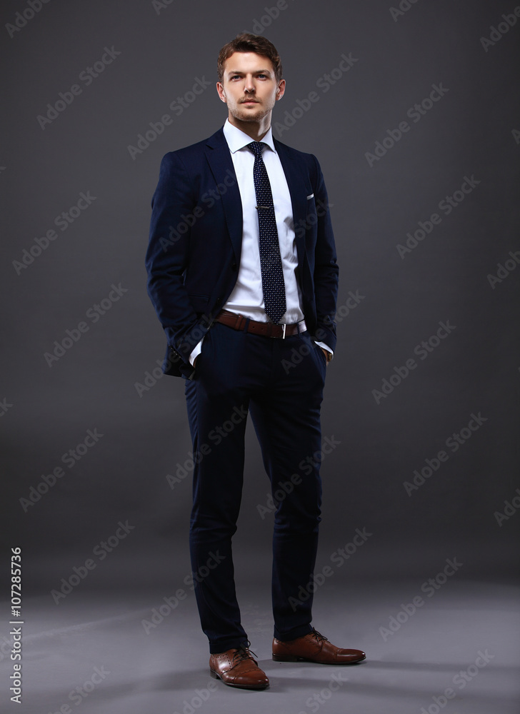 Cool businessman standing on grey Cool businessman standing on grey
