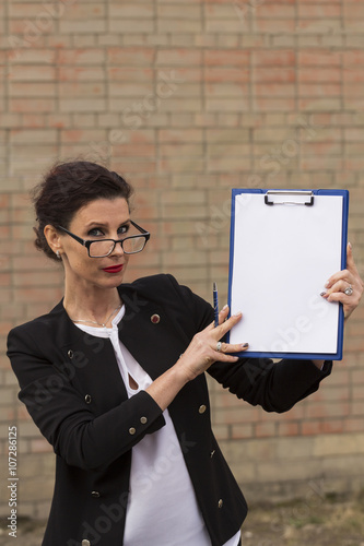 woman office worker holding a clip board with white paper