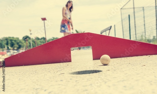 Attractive young woman playing mini golf. photo