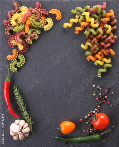 pasta of different colors, tomatoes, garlic, pepper, rosemary in