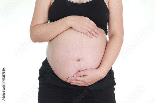 pregnant woman caressing her belly on white background