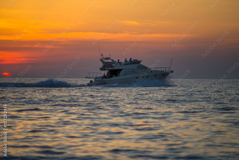 Luxurious boat sailing during sunset in Santorini, Greece.