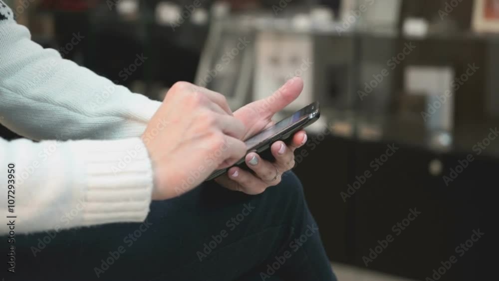 Young girl using a smart phone at the beauty salon