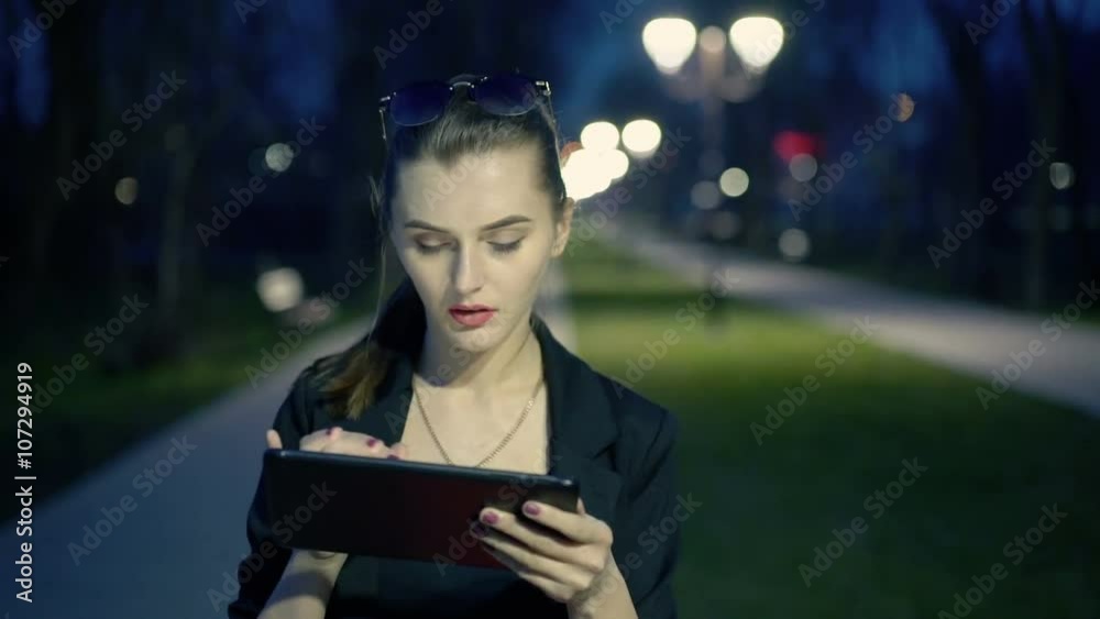Beautiful girl enjoys the tablet at night Beautiful girl enjoys the tablet at night