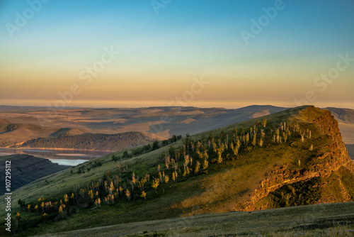 Beautiful landscape with hills and wide river at sunset 