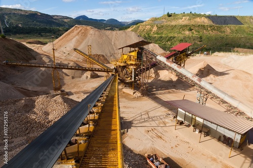 Gravel Aggregate Extraction - Gravel pit in mountain area with machinery and distribution tapes gravel according sizes, lots of gravel and sand for construction industry