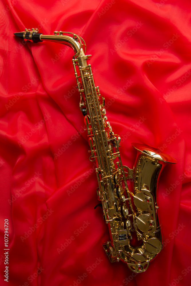 Naklejka premium beautiful golden saxophone on a red background