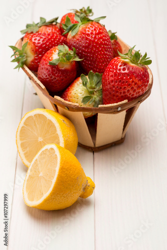 Strawberries in a small basket and lemon