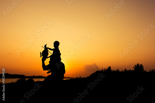 silhouette of dad and son plane plane sunset background