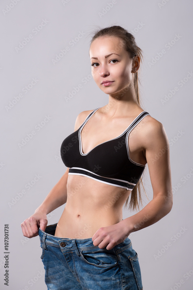girl shows her weight loss by wearing an old jeans girl shows her weight loss by wearing an old jeans
